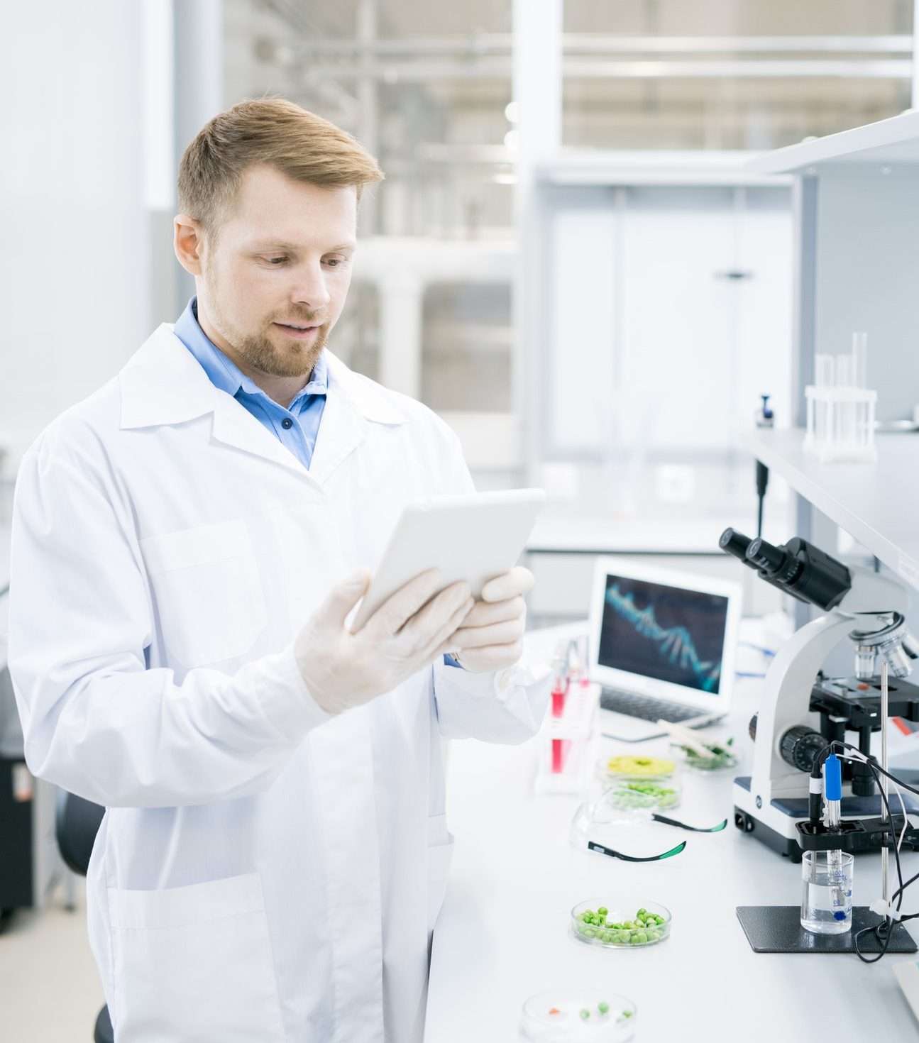 modern scientist using tablet in laboratory e1621063231490